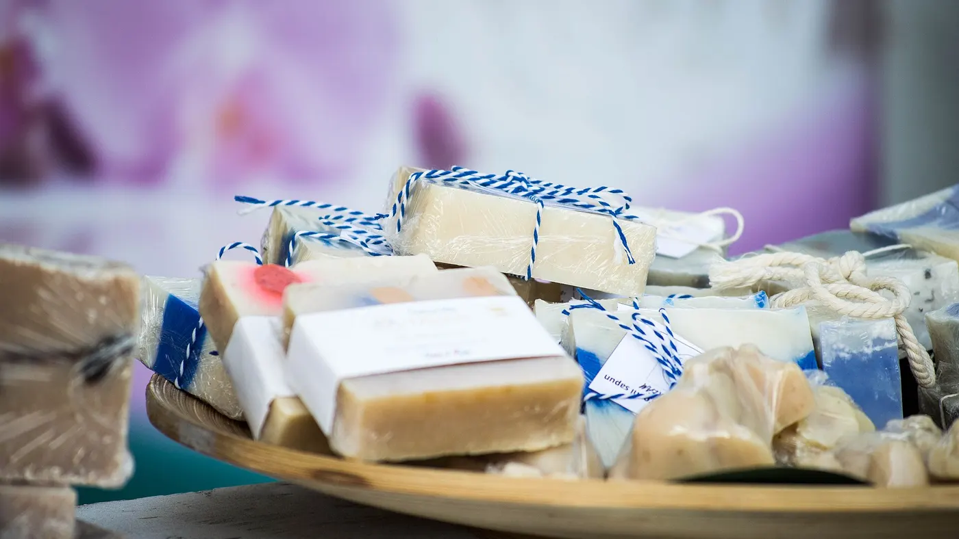 Des savons artisanaux posés sur un plateau en bois