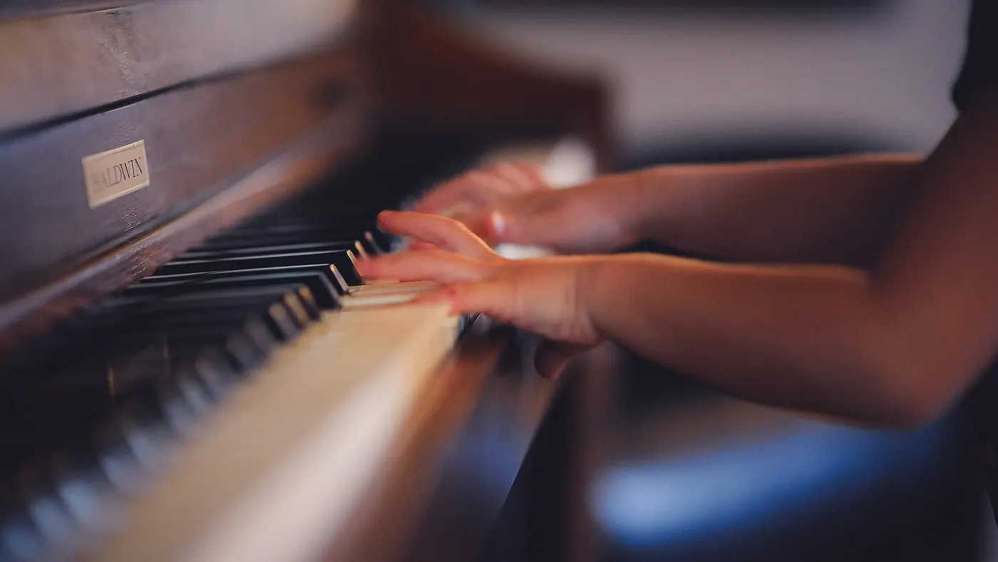 Des mains posées sur le clavier d’un piano