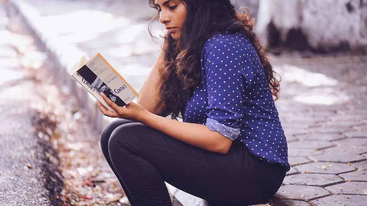 Une adulte absorbée dans la lecture d’un livre