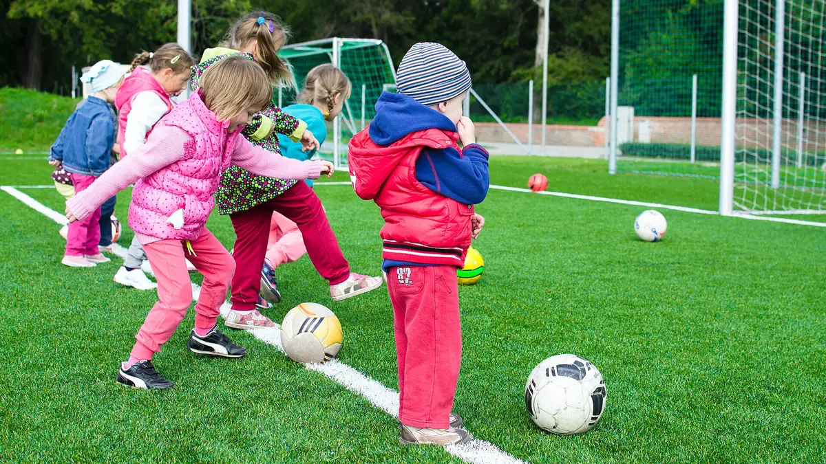 Des enfants d’âges différents qui jouent au ballon ensemble